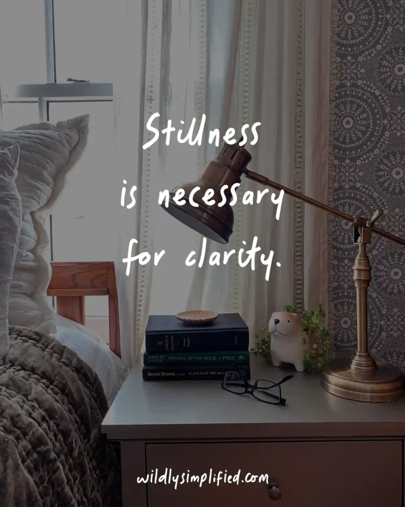 "Stillness is necessary for clarity." written over a photo of a bedroom side table.